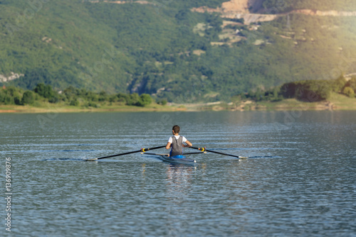 The young sportsman is rowing on the racing kayak
