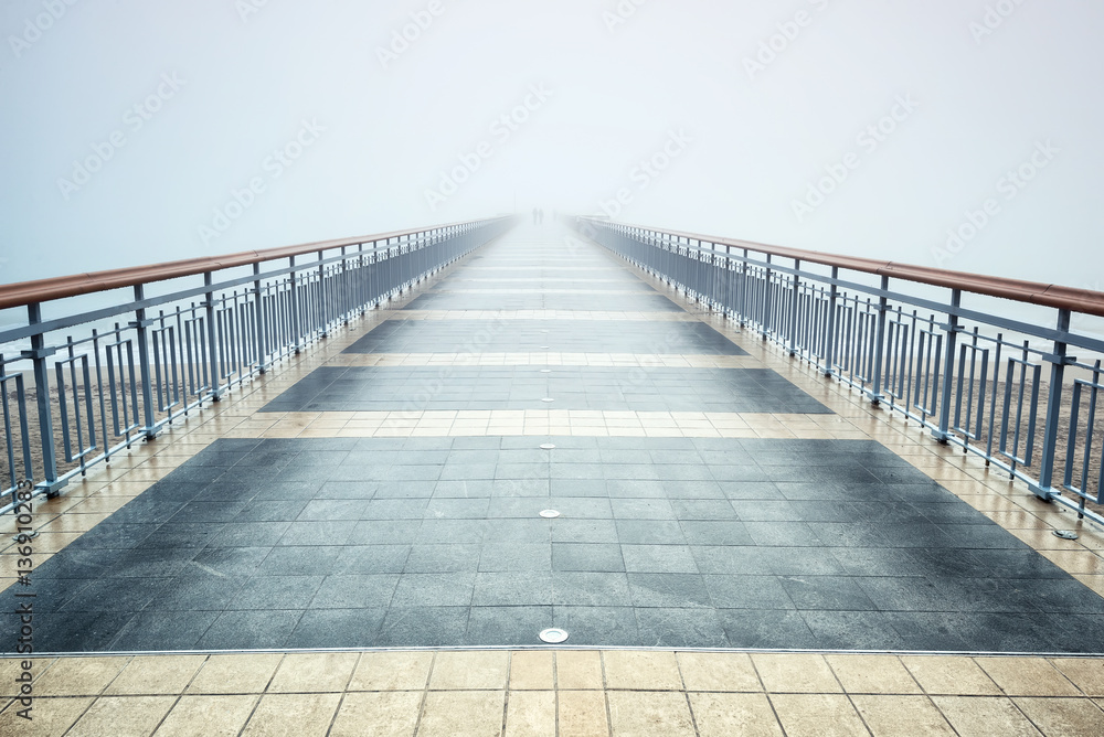 Bridge in а foggy morning /
A morning view of a bridge and silhouettes of people disappearing into the mist