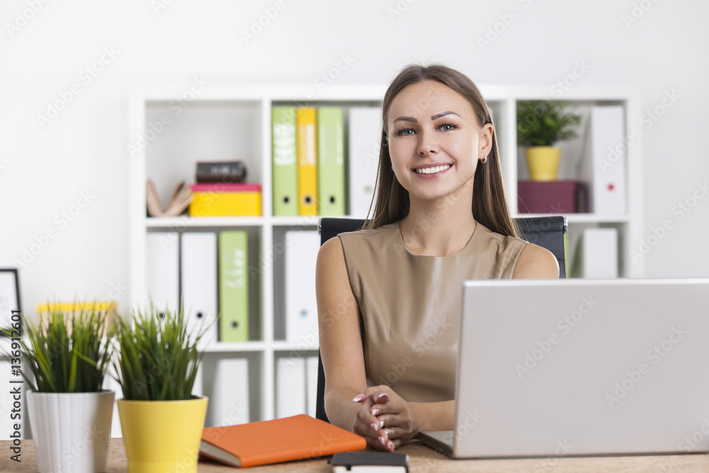 Portrait of a smiling woman in beige in office Portrait of a smiling woman in beige in office