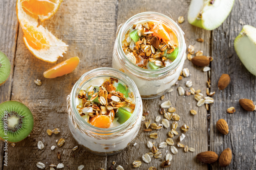Yogurt, granola and fruits in a jars for delicious breakfast. Traditional American healthy food. Top view Instagram style photo. Yogurt, granola and fruits in a jars for delicious breakfast. Traditional American healthy food. Top view Instagram style photo.