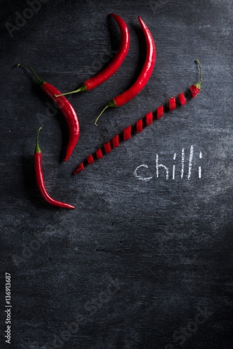 Photo of cut chilli pepper over dark background.