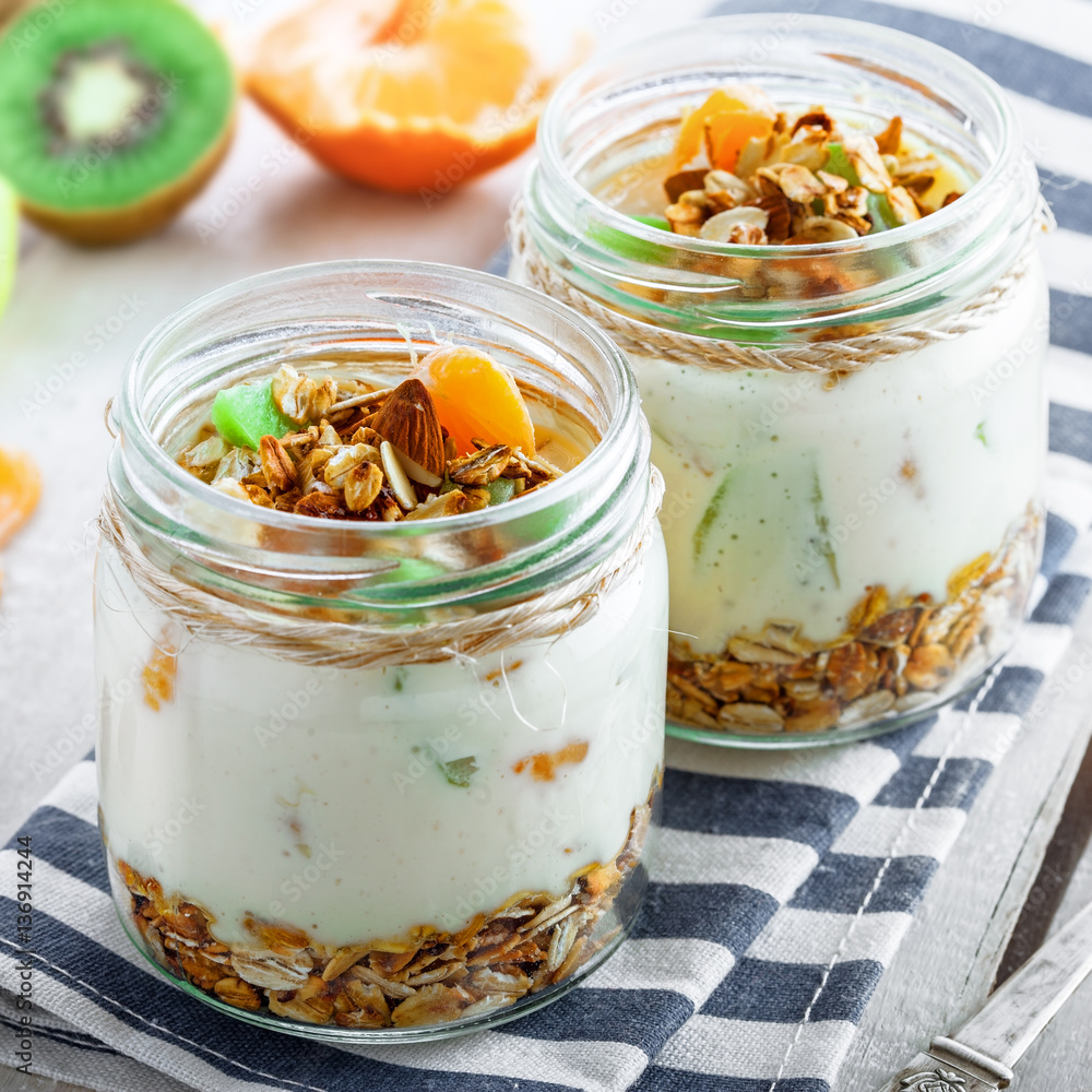 Granola with yogurt and fruits in a rustic jar. Delicious healthy American food for breakfast. Traditional US snack. Granola with yogurt and fruits in a rustic jar. Delicious healthy American food for breakfast. Traditional US snack.