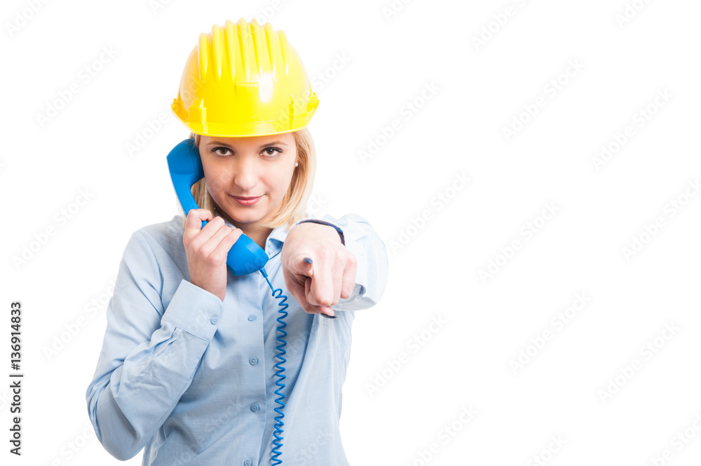 Female architect wearing helmet holding telephone receiver and p Female architect wearing helmet holding telephone receiver and p