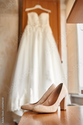 wedding shoes and bride in a bedroom