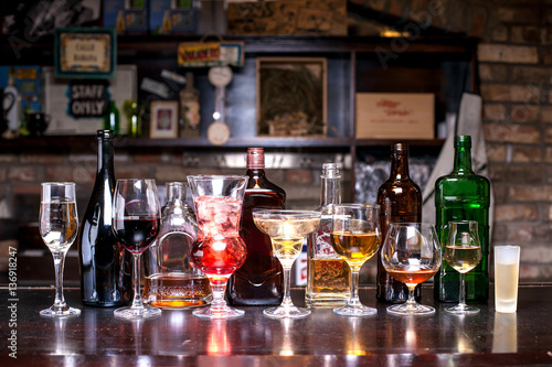 Foto many different bottles of alcohol in different shapes, glasses with alcohol of v