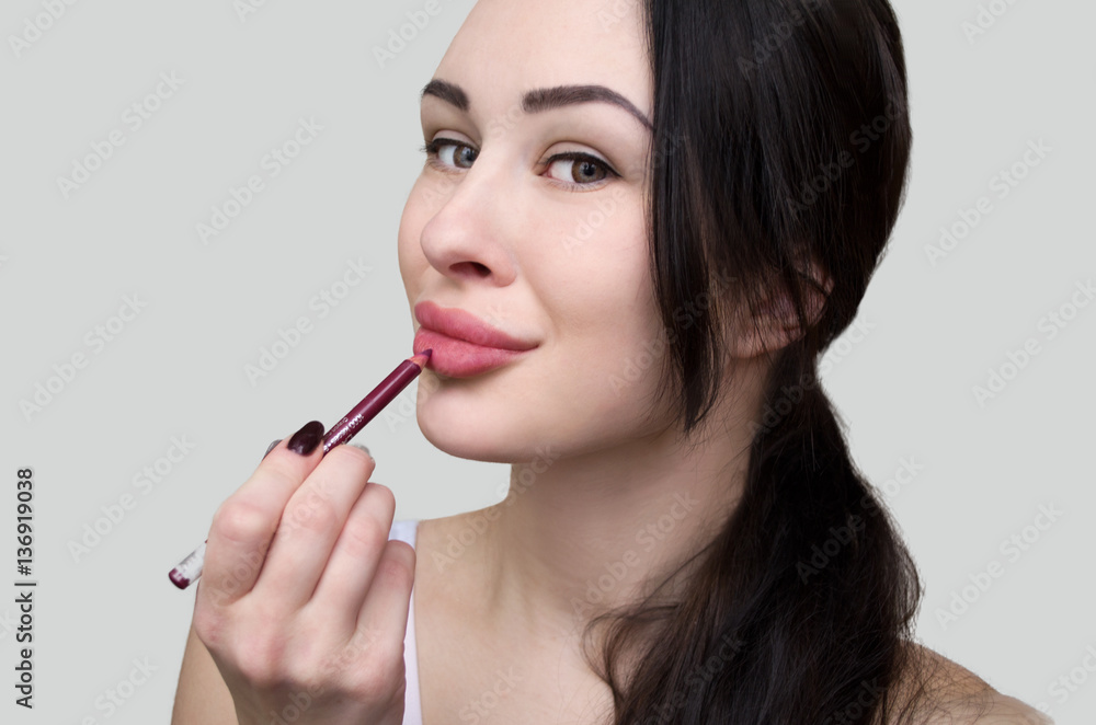 Woman putting makeup lipstick. Caucasian girl putting lip gloss pink lipstick smiling happy, close up. Woman putting makeup lipstick. Caucasian girl putting lip gloss pink lipstick smiling happy, close up.