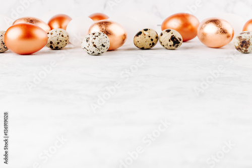 Border with Painted Easter copper eggs and quail eggs with copy space. Holiday background.