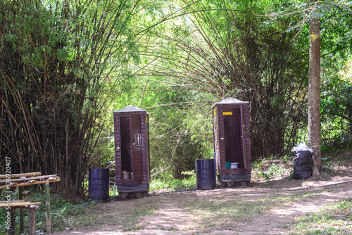 Temporarily toilet with trash can in forest. photo