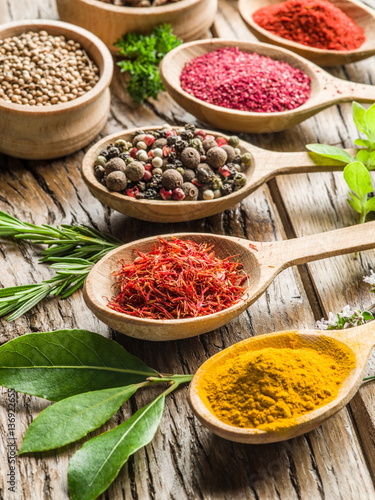 Assortment of colorful spices in the wooden spoons.