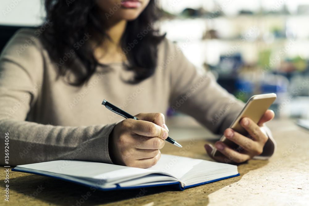 Close up of woman hands with phone and pen Close up of woman hands with phone and pen