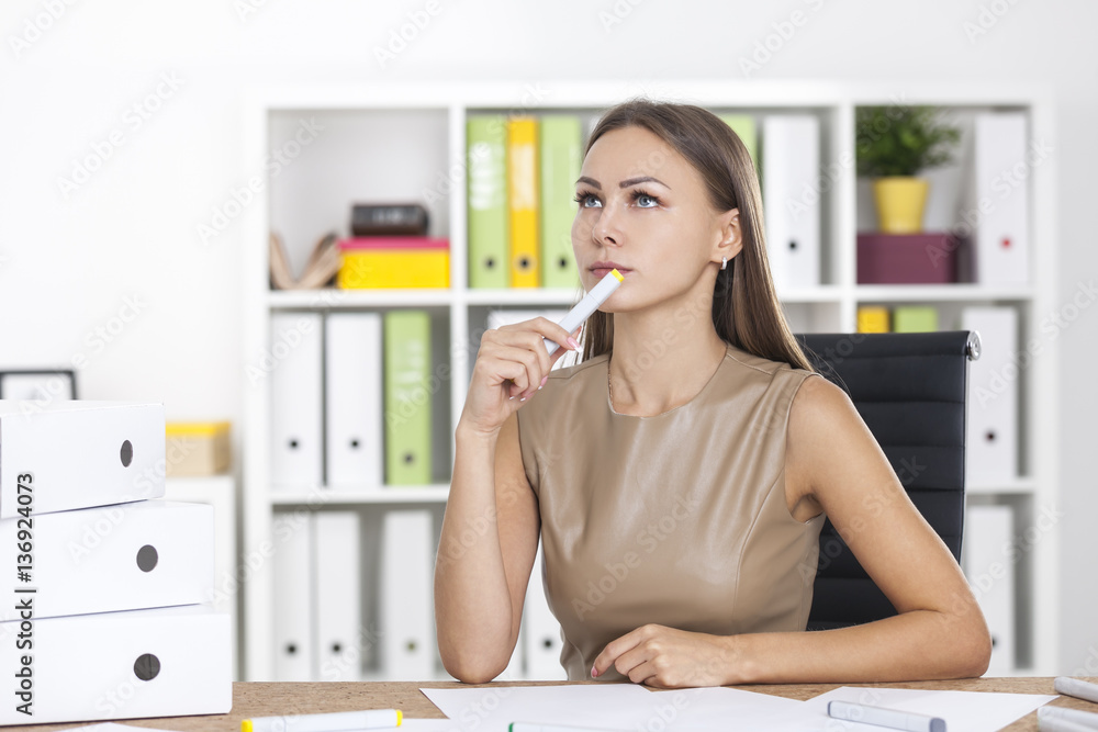 Portrait of a thinking blond woman with marker