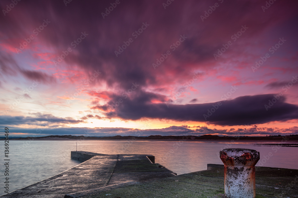 Naklejka premium Beadnell Harbour at Sunset, Beadnell is a village on the Northumberland coastline, with a small fishing harbour set into Beadnell Bay.