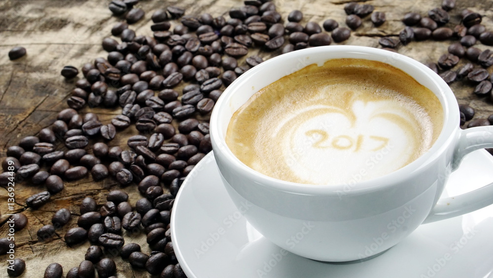 Cappuccino Coffee. A cup of latte, cappuccino or espresso coffee with milk put on a wood table with dark roasting coffee beans. Drawing the foam milk on top. Cappuccino Coffee. A cup of latte, cappuccino or espresso coffee with milk put on a wood table with dark roasting coffee beans. Drawing the foam milk on top.