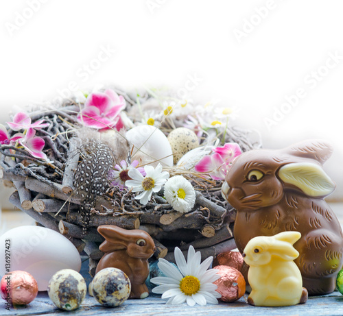 Happy Easter: nest with Easter eggs, feathers, flowers and chocolate bunnies :)