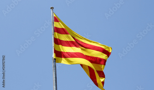 The flag of Catalonia over a blue sky photo