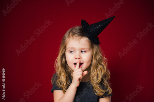 Fotografia маленькая волшебница приложила палец к губам
