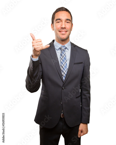 Confident young businessman doing a call gesture