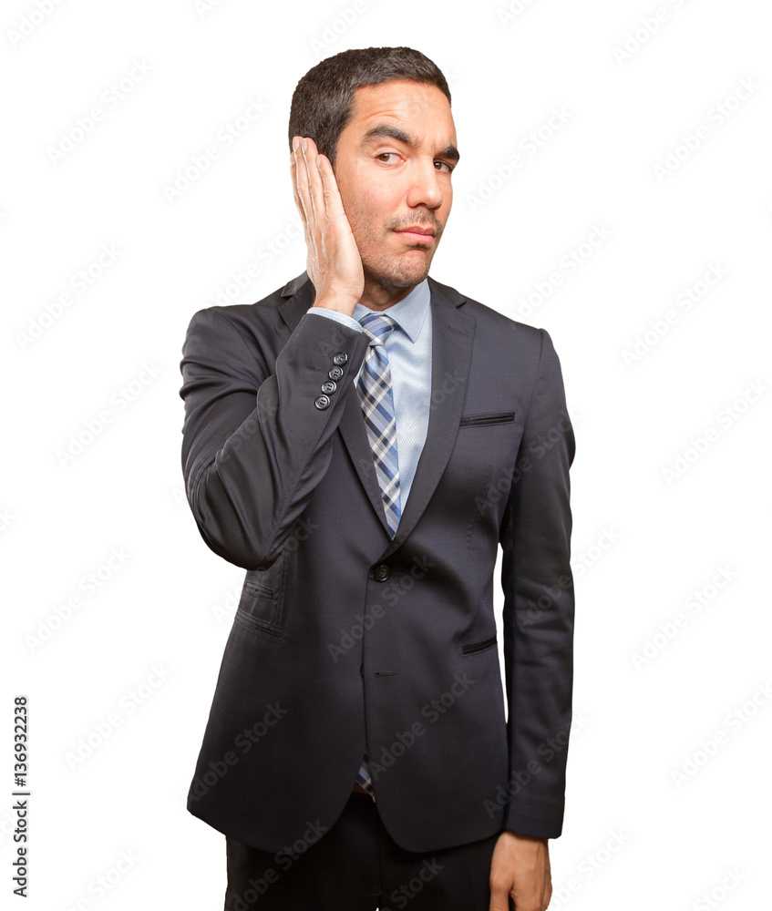 Worried young businessman covering his ears