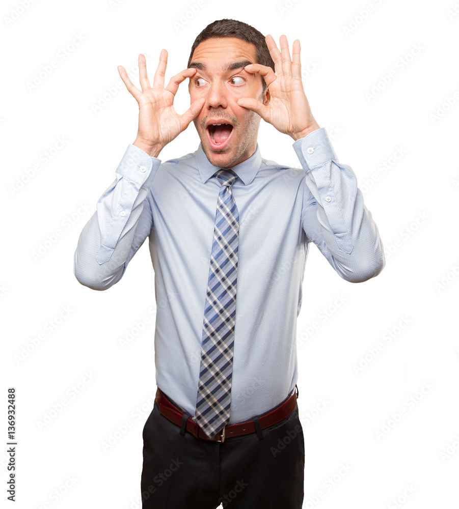 Concentrated young man doing an observation gesture Concentrated young man doing an observation gesture