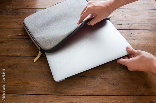 hand pulling laptop out of laptop bag