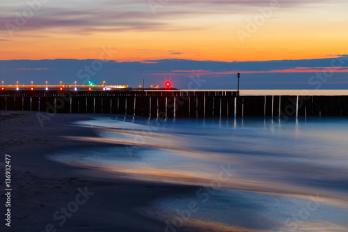 sunset on the beach with a wooden breakwater  long exposure