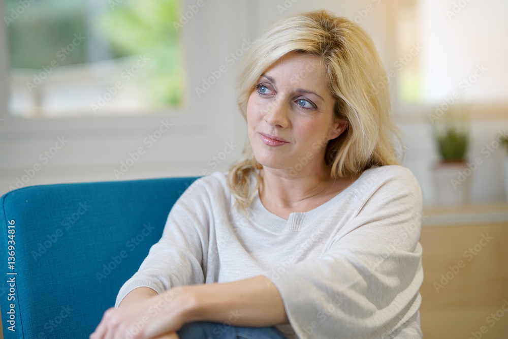 Portrait of middle-aged blond woman relaxing at home