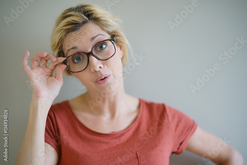 Blond woman with eyeglasses having a surprised look