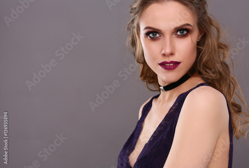 Close up portrait of beautiful young woman face. Isolated on gray background.