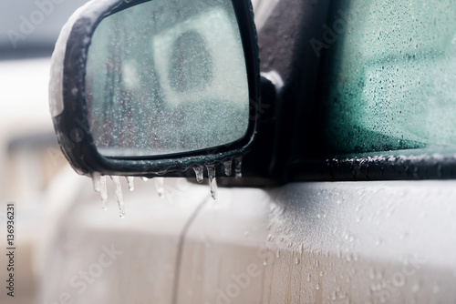 Car mirror with icicles, close-up