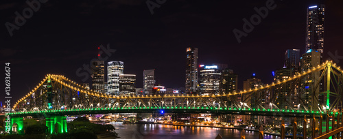 Panoramic view of Story bridge in yellow and green light at nigh time in Brisbane Australia 
