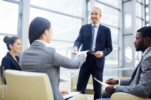 Business leader giving financial document to new partner