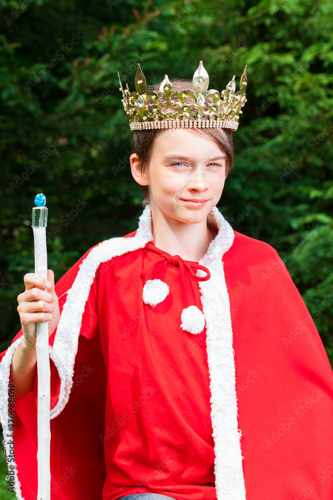 Cute teenager boy wearing crown and red costume holding a scepter  pretending to be a king Stock Photo | Adobe Stock