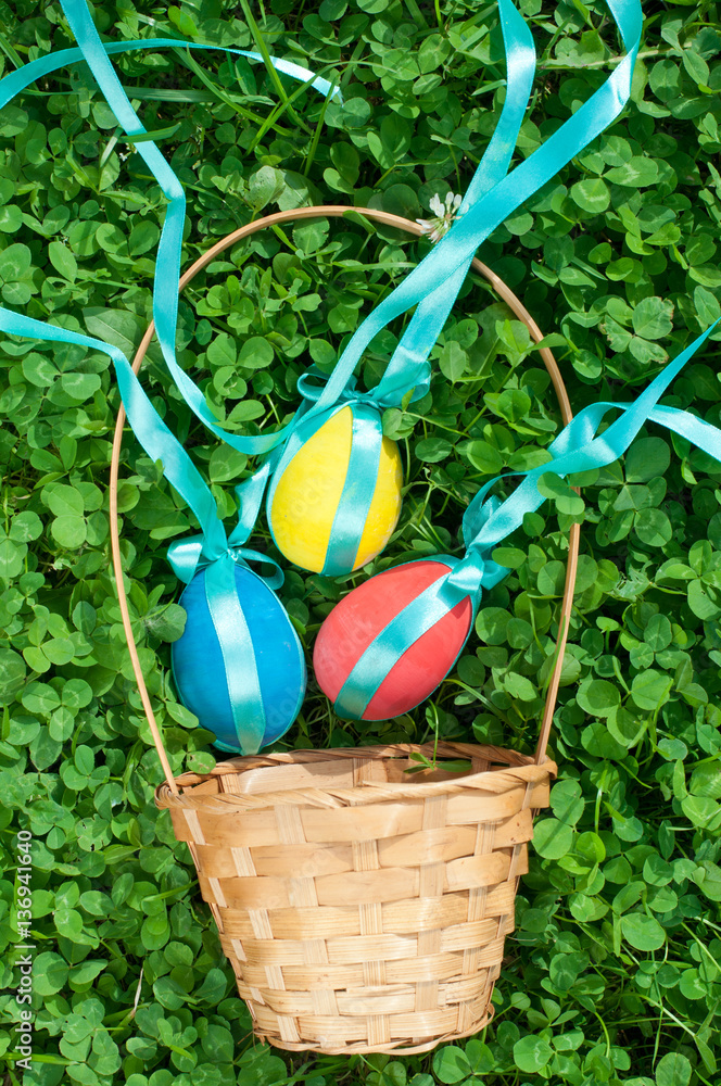 Colorful Easter eggs with basket in the grass Colorful Easter eggs with basket in the grass