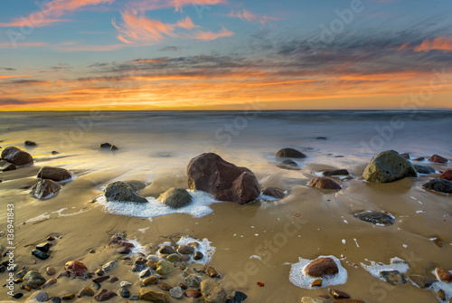 boulders on the sea beach at sunset