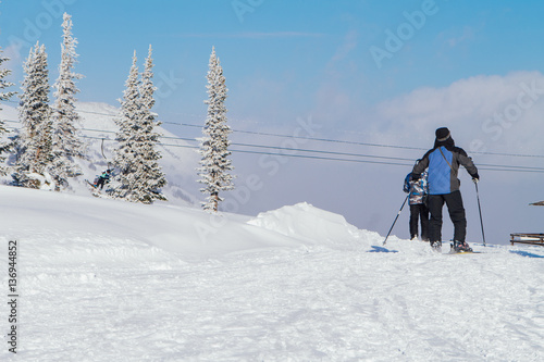 People in ski suit holding snowboards