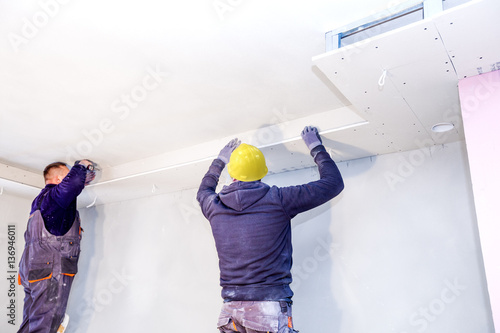 Fotografie Construction worker imposes a finishing coat on fire