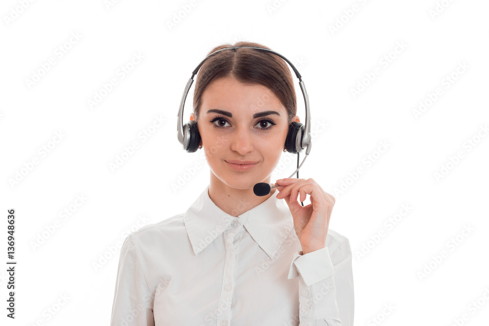 pretty young brunette call office worker woman with headphones and microphone looking at the camera isolated on white background pretty young brunette call office worker woman with headphones and microphone looking at the camera isolated on white background