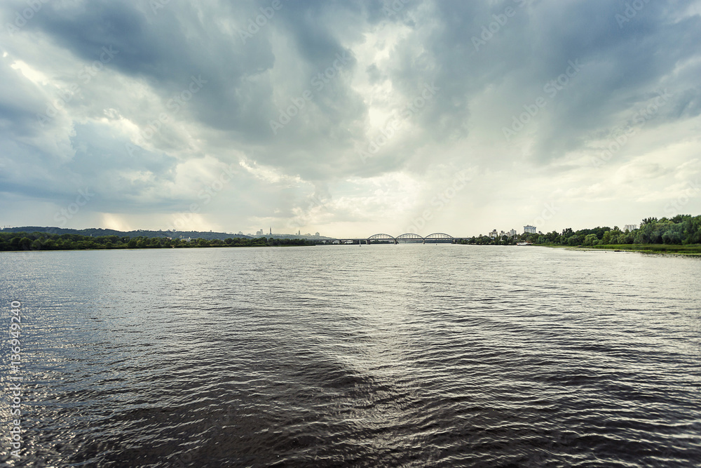 River, brifge and Kiev,Water surface with ripples and sunrays reflections,View of Dnipro river