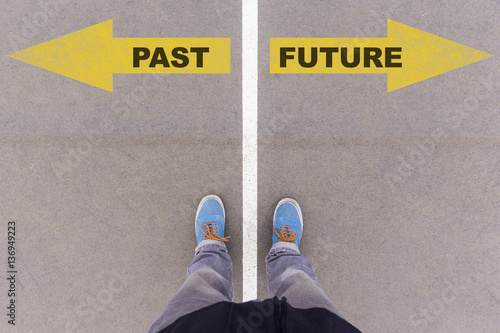 Past and future text arrows on asphalt ground, feet and shoes on photo