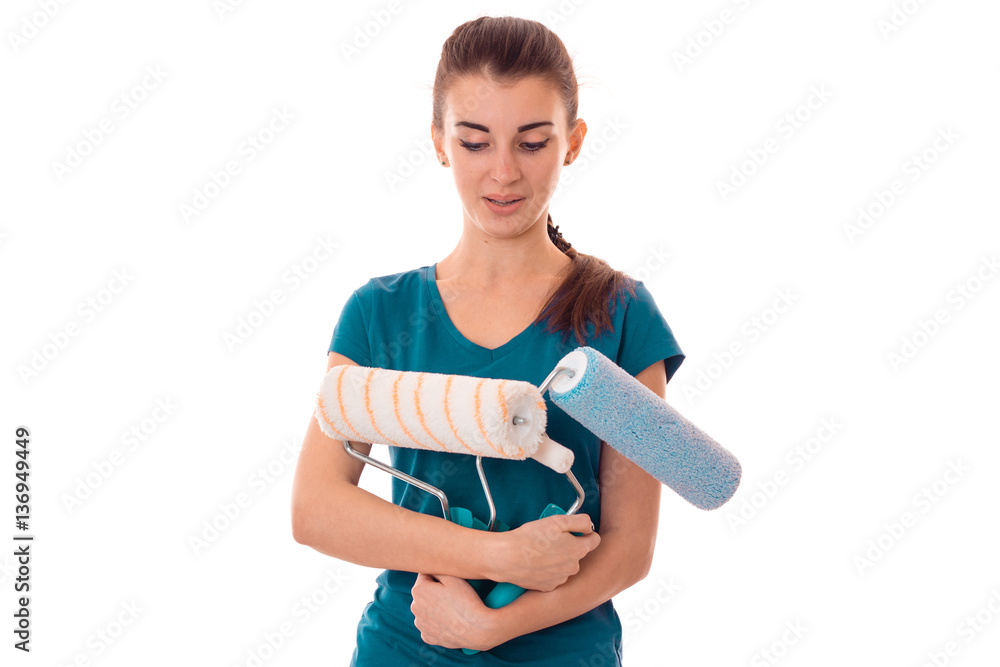 funny young brunette lady makes renovation in gloves with paint roller in her hands isolated on white background funny young brunette lady makes renovation in gloves with paint roller in her hands isolated on white background