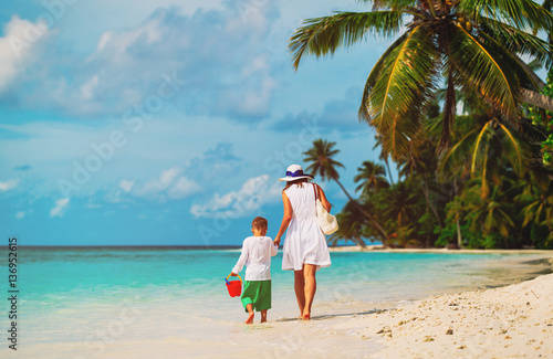mother and little son walking on beach