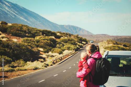 family travel by car-mother with baby on road in mountains