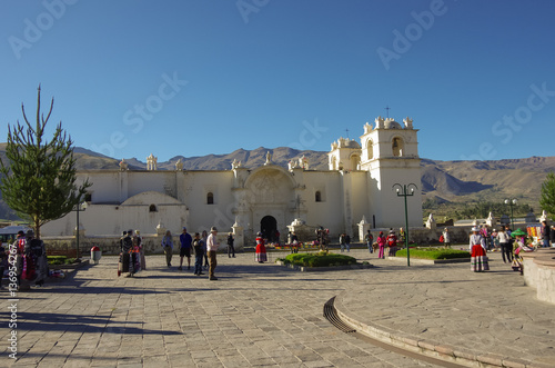 Main square and Church of the Immaculate Conception with mountains behind in Yanque, Colca Canyon, Peru.  photo