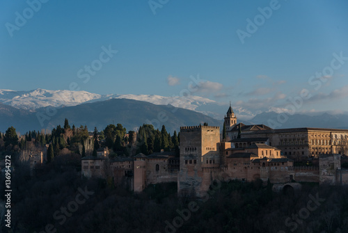View of Alhambra Palace in Granada, Spain with Sierra Nevada mountains in snow at the background . Granada, Spain © smoke666