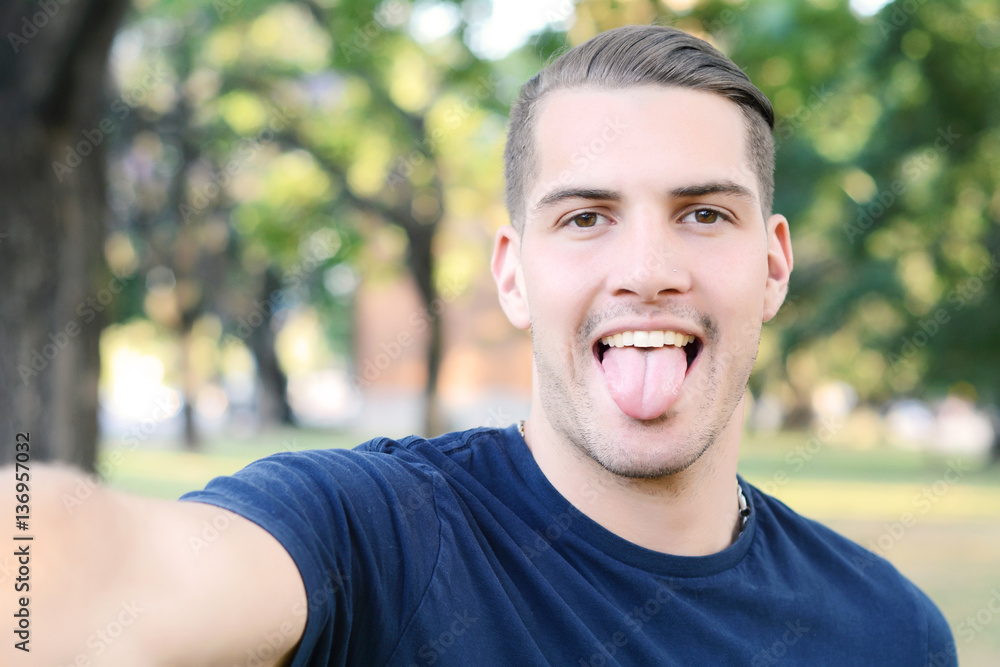 Young latin man taking a selfie in a park. Young latin man taking a selfie in a park.