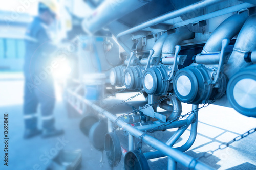 The man checking fuel truck pipeline and machanical for draining the oil to oily tank at gas station.