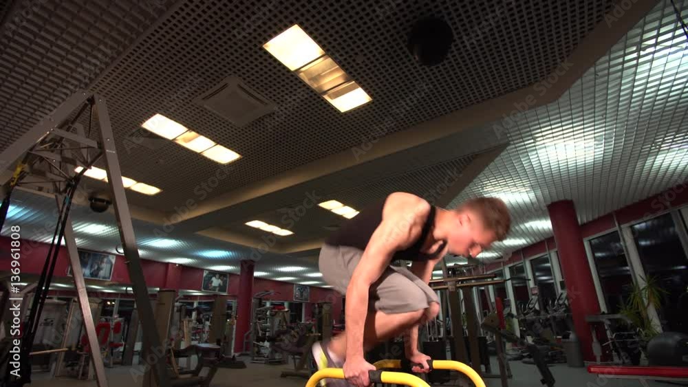 Bodyweight exercise, man standing on hands at gym Bodyweight exercise, man standing on hands at gym