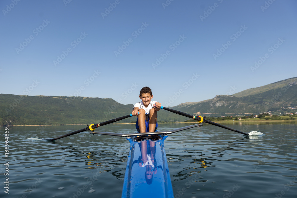 The young sportsman is rowing on the racing kayak