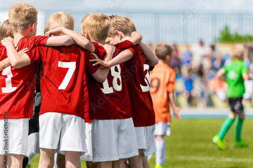 Boys Soccer Team. Children Football Academy. Kids Soccer Players in Red Shirts Standing Together on the Pitch. Youth Soccer Motivational Speech. Coach Motivational Talk With Young Boys