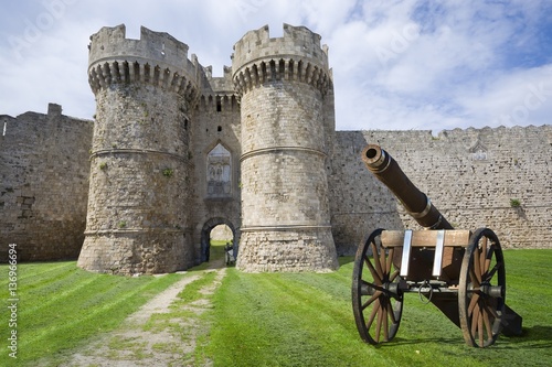 Artillery gun with fortifications of the Old Town of Rhodes in the background - Marine Gate (Sea Gate), Greece